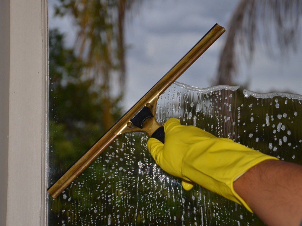 A window being cleaned with a squeegee